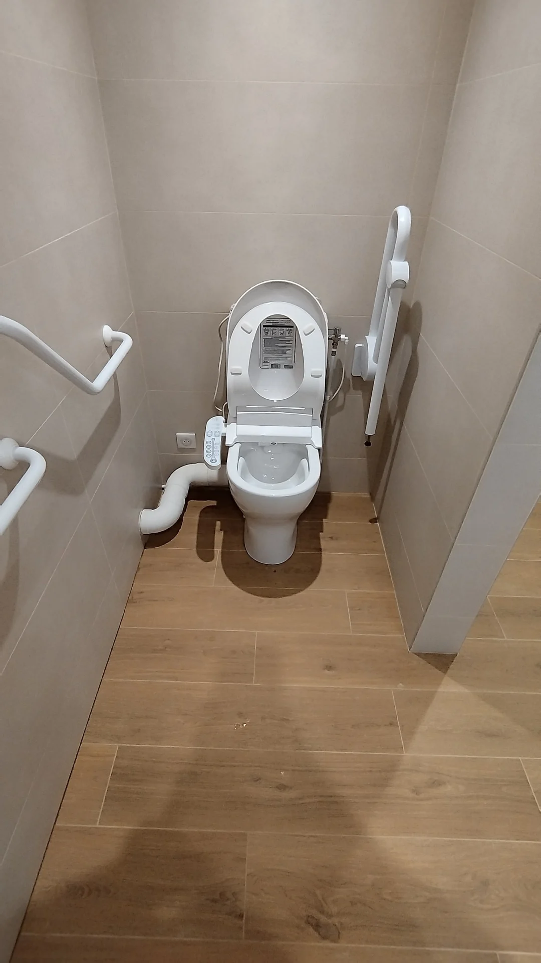 Le WC PMR et ses barres de maintien. WC PMR encadré de barres de maintien, dont une barre relevable, dans un appartement à Montpellier